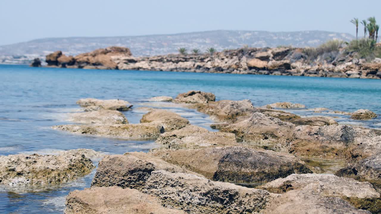 Blue bay, lagoon on the Mediterranean Sea, windy and sunny weather, with mountains in the background, Cyprus, Paphos