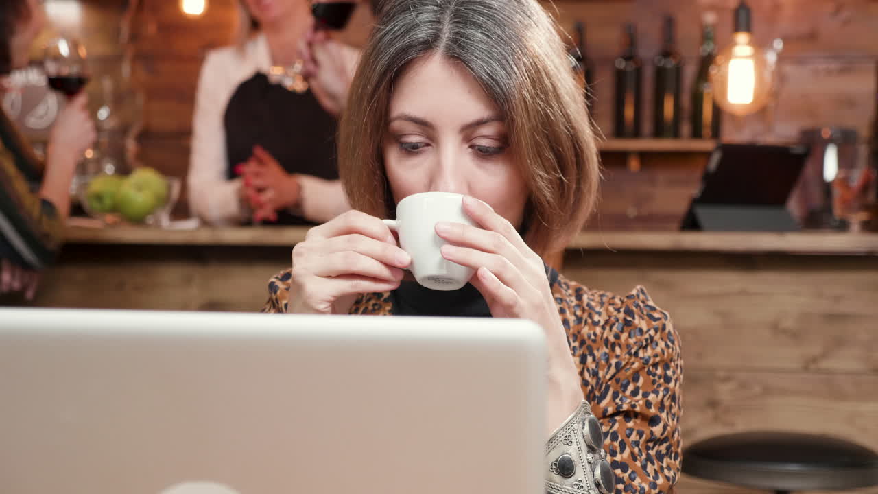Woman working on laptop in cafe