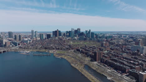 Red-brick-apartment-buildings-in-residential-neighbourhood-on-river-waterfront-and-downtown-skyscrapers-in-background.-Boston,-USA