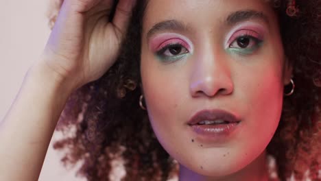 mujer biracial con cabello oscuro en luz azul y rosa, cámara lenta