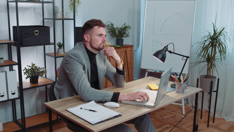 business man in suit thinking about an important creative project work decision on laptop at office