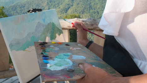 artist painting mountains outdoors