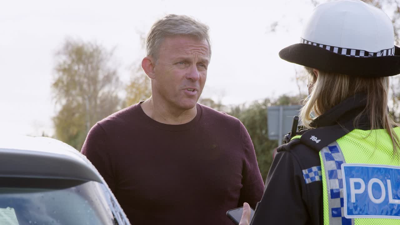 여성 교통 경찰관 은 도로 교통 사고 에서 휴대 전화 로 운전자 의 진술 을 취합니다.