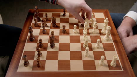 chess game moves, two men moving and taking pieces with view of whole board, bishop takes knight, knight takes bishop, slow motion