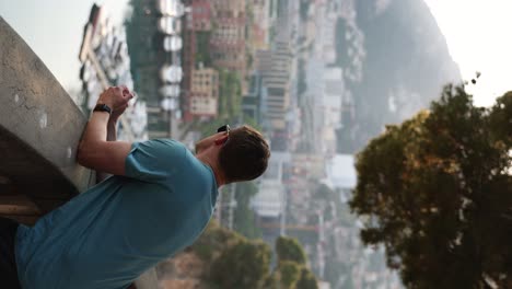 turista masculino en mónaco, con vistas al puerto deportivo en la costa al atardecer - vertical