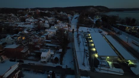 Aerial-birds-eye-shot-of-train-on-snowy-track-in-american-town-at-night