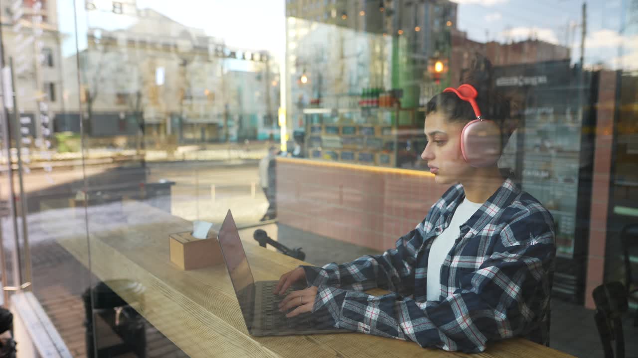 Mulher jovem a trabalhar num portátil num café