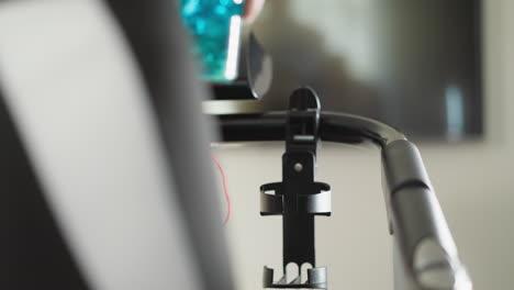 woman takes water bottle running on treadmill at home closeup. athlete refreshes with drink exercising on machine in gym. keep hydrated on workout