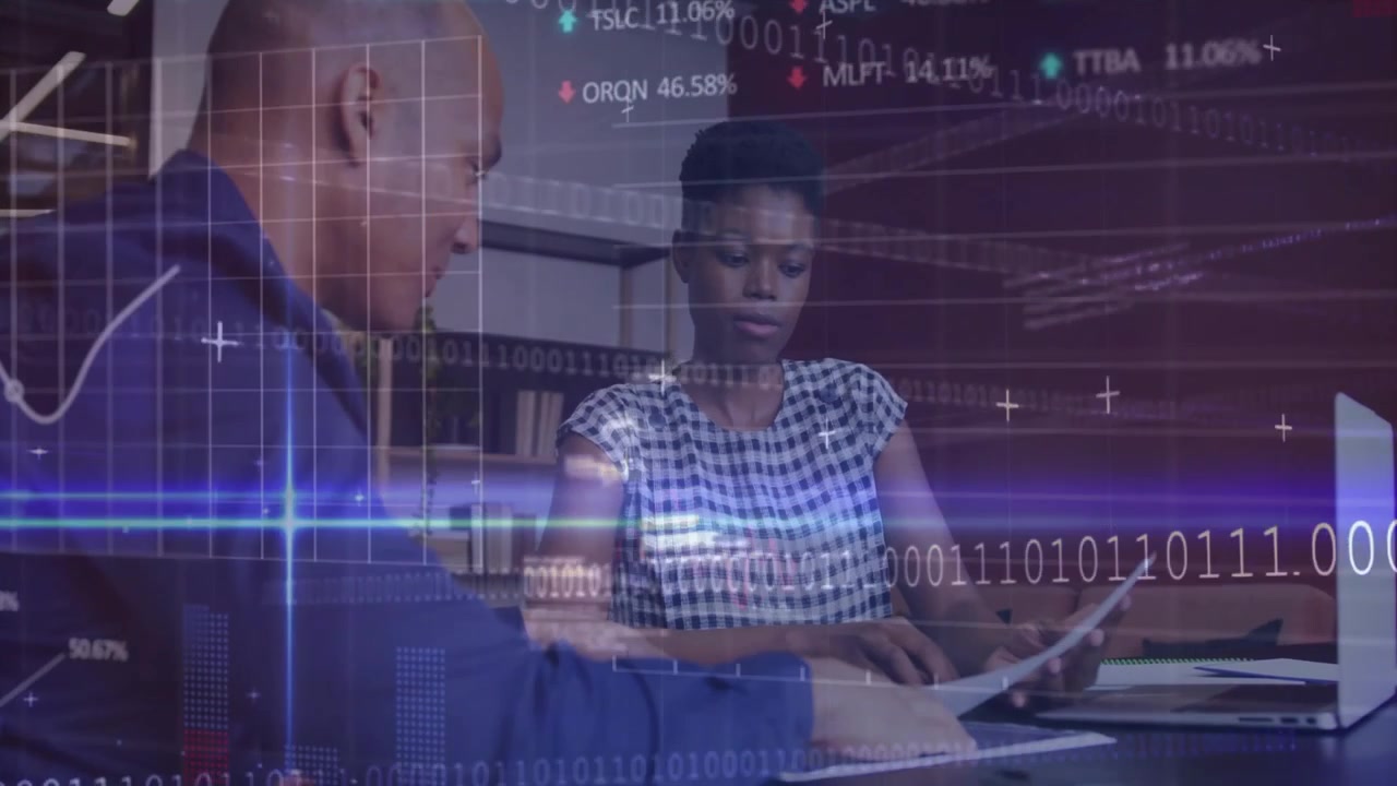 Man leaning reviewing financial charts on laptop while woman scanning reports with binary code