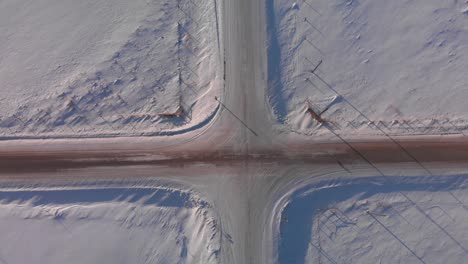 aerial top view of a snow-covered intersection in the countryside of canada