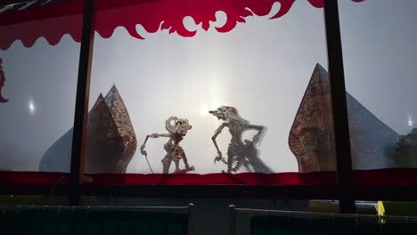 silueta de las marionetas javanesas wayang kulit o sombras de java, indonesia espectáculo de marionetas por titiritero