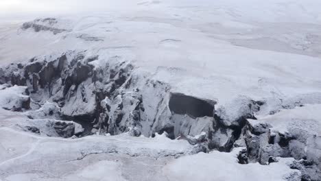 aerial approaching shot of massive iced fjadrargljufur canyon during frosty cold day in iceland