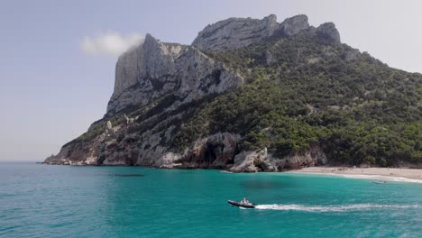 Boat-on-Cala-Sisine-Beach,-Tourist-Destination-on-Baunei-Coast's-Gulf-of-Orosei-on-Sardinia-Island,-Aerial