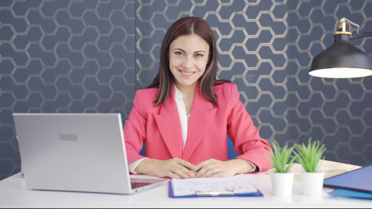 joven mujer de negocios asintiendo a la cámara. aprobación.