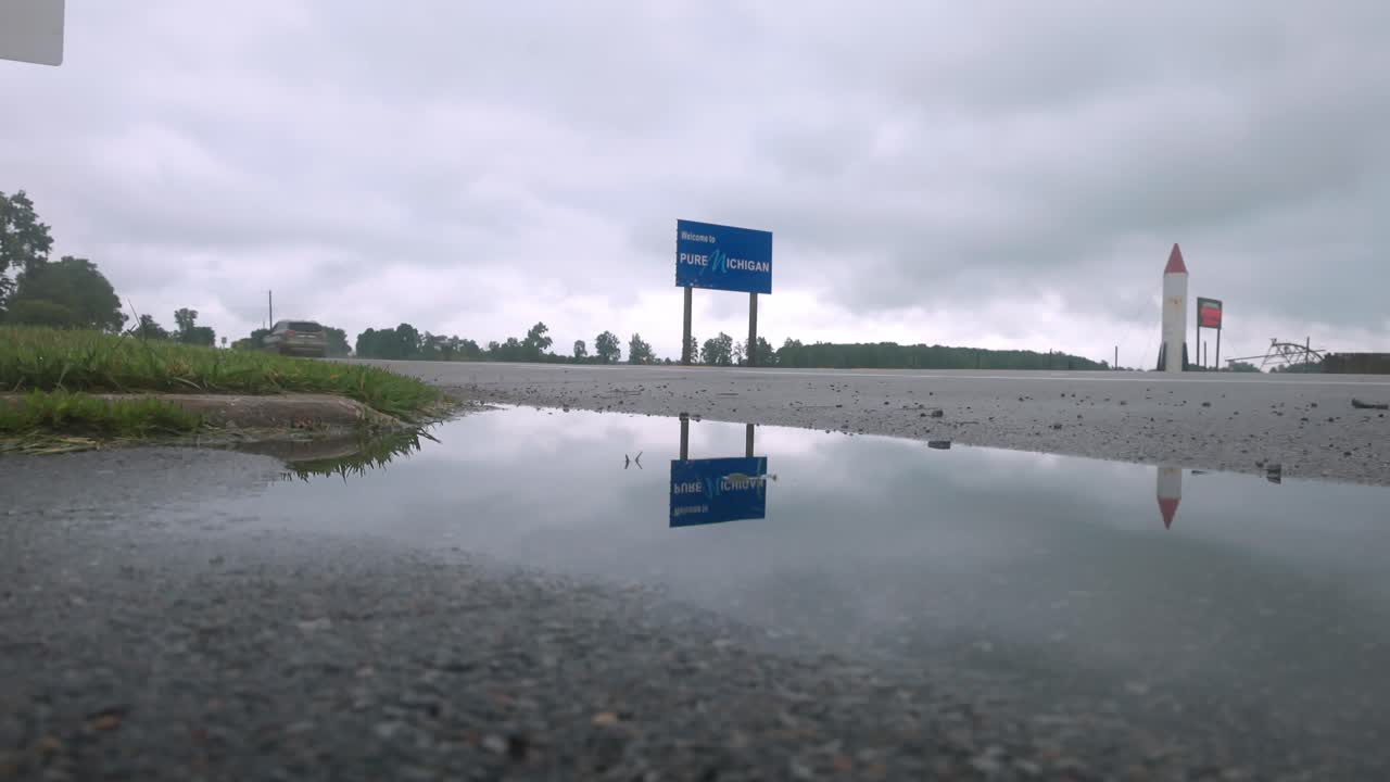 안정적인 와이드 샷과 연못을 갖춘 미시간과 인디애나 사이의 주 경계선에 있는 순수 미시간 표지판에 오신 것을 환영합니다.