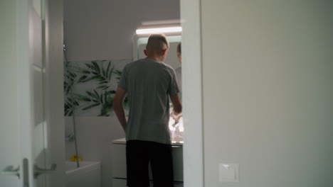 teenage boy washing hands in the bathroom