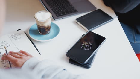 Close-Up-Of-Two-Mobiles-Phone-To-Phone-Wirelessly-Charging-On-Desk