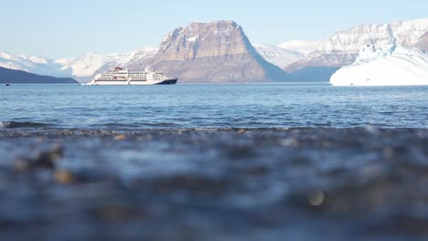 Greenland,-Northeast-National-Park,-Glacial-Water-Flowing-Into-the-Sea-on-Sunny-Spring-Day,-Low-Angle-Slow-Motion