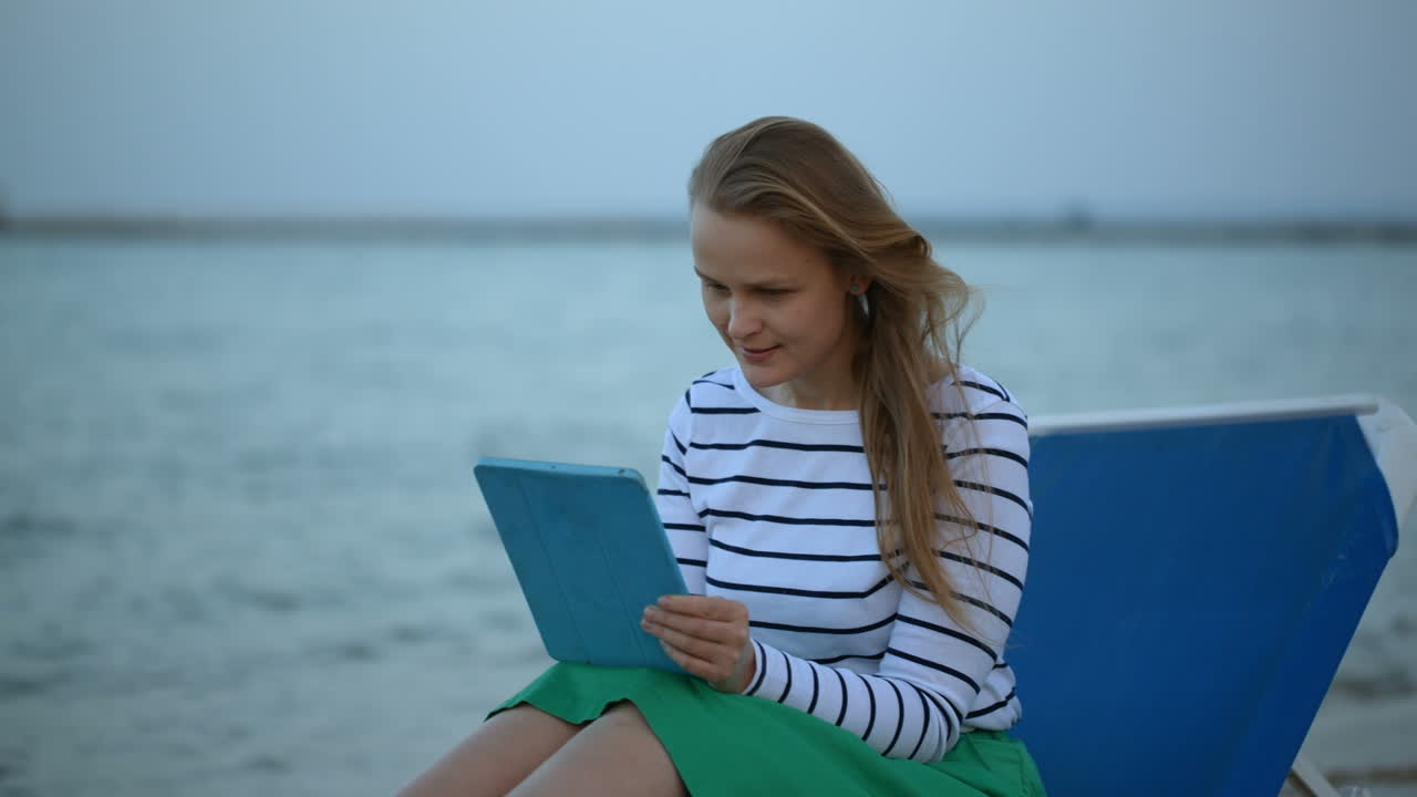 mujer con touchpad junto al mar