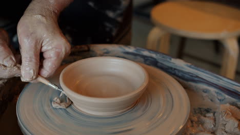 artista de cerámica formando un cuenco en una rueda