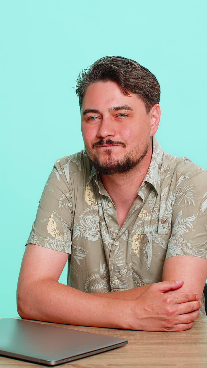 Man sitting at table closing laptop smiling with relief happy after finishing work or online task