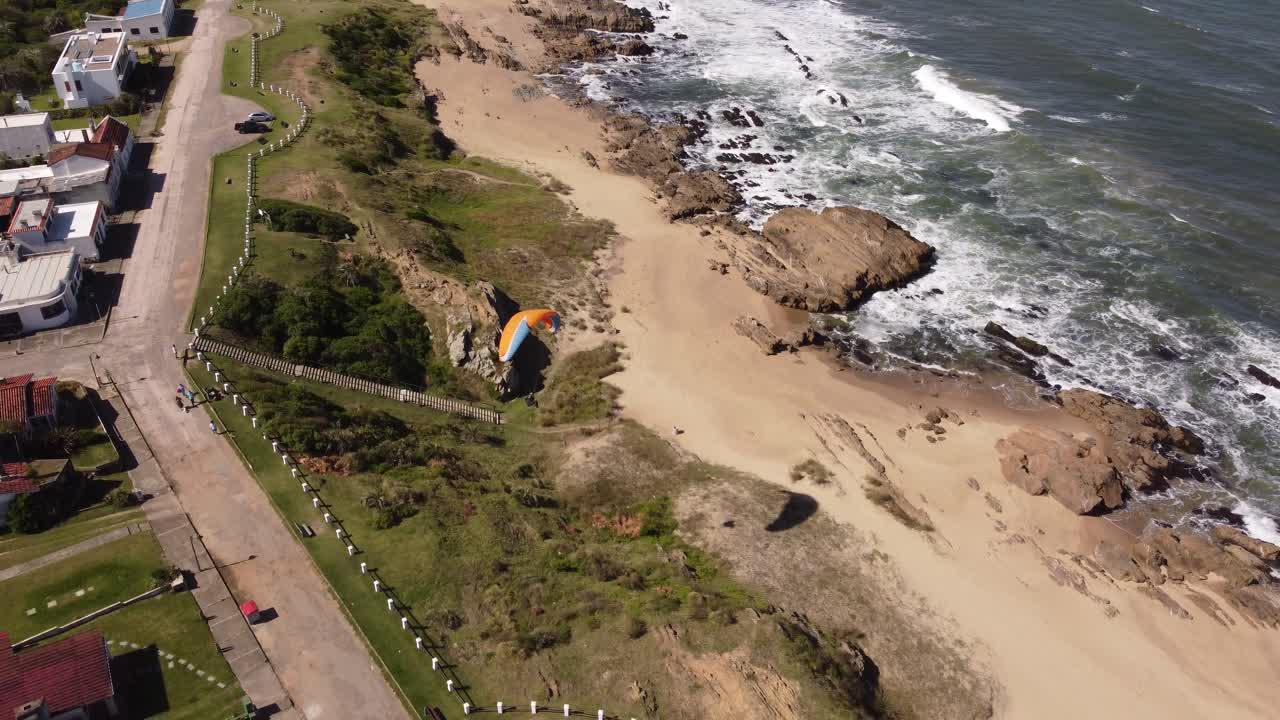 parapente despega del acantilado y vuela en la playa de la pedrera en uruguay
