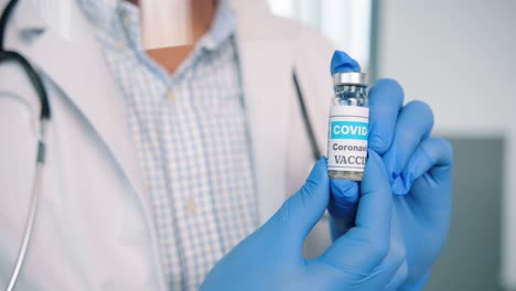 Close-Up-Shot-Of-Healthcare-Worker-Specialist-In-Protective-Uniform-Holding-In-Hands-In-Gloves-Ampoule-With-Coronavirus-Vaccine,-Covid-19-Vaccination-Concept,-Virus-Cure-Medicament,-Healthcare