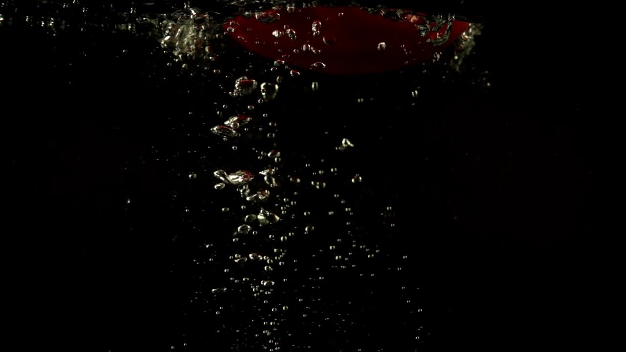 Peperone dolce che cade. Slow motion. Sfondo nero.