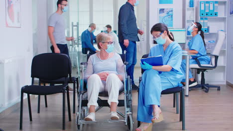 nurse taking notes from disabled senier patient