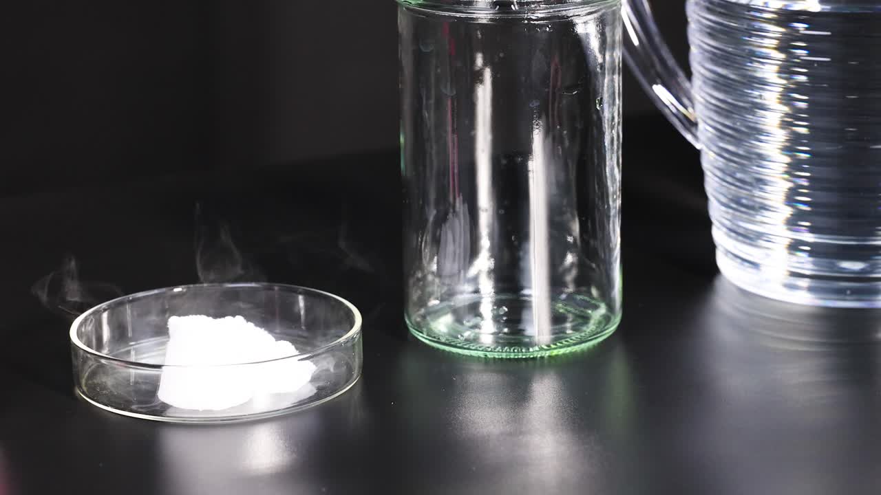 통제된 조명 조건 하에서 눈에 보이는 증기가 있는 페트리 접시에서 건조한 얼음이 창하는 것을 보여주는 시스