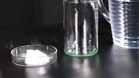 a sequence showing dry ice sublimating in a petri dish, with visible vapor, under controlled lighting conditions
