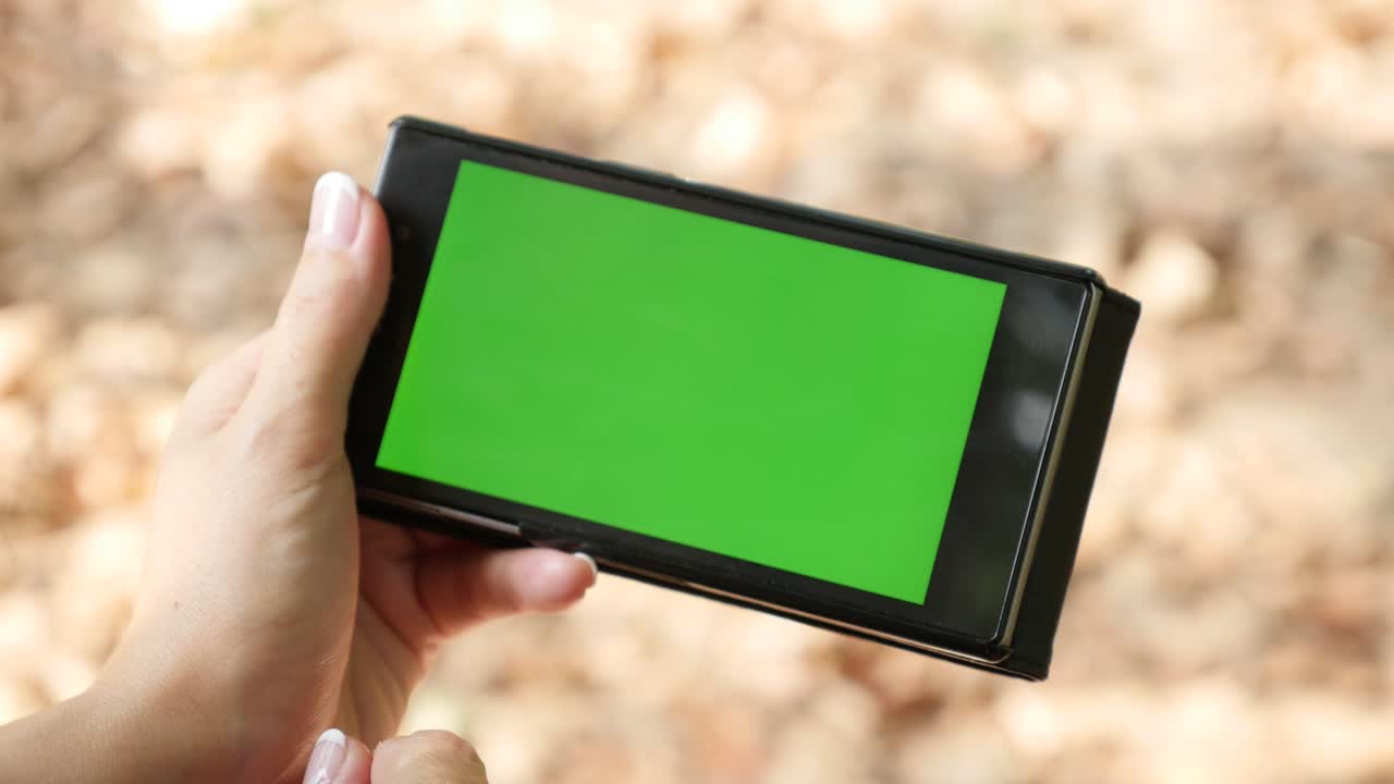 녹색 화면 스마트 폰 디스플레이를 사용하는 여성 자연 4k