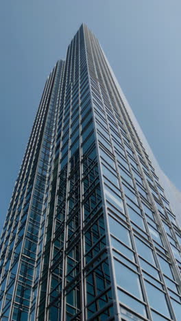 modern glass skyscraper against a clear blue sky