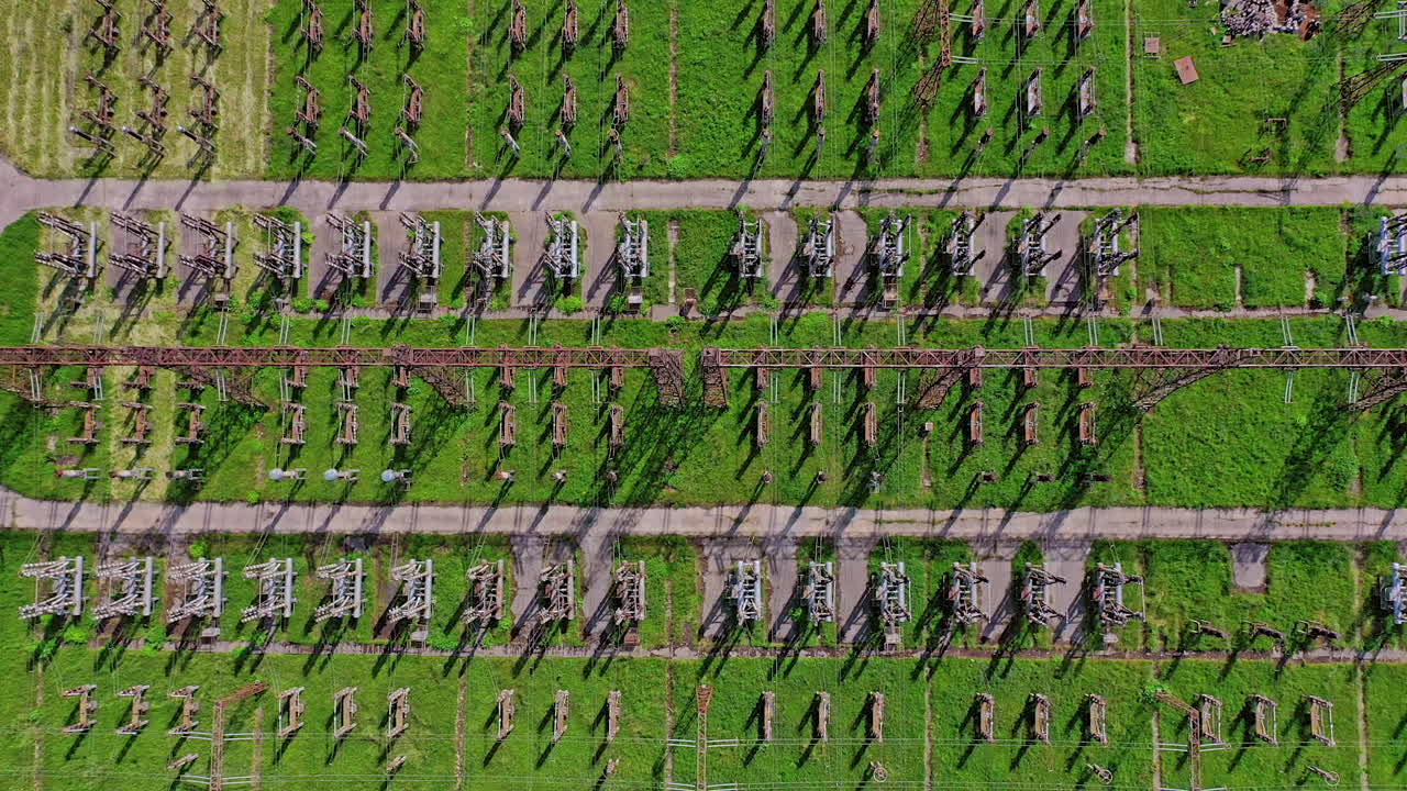 Power transmission lines. Flight over high voltage pillars on green field background. Aerial view.