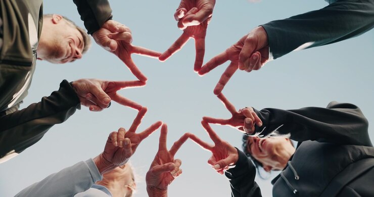 Gruppo eterogeneo di persone che forma una stella con le mani