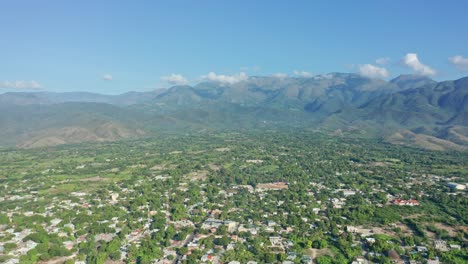 paisaje de exuberante vegetación y pueblo con montañas al fondo en neiba, república dominicana - panorámica aérea