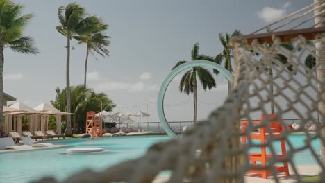 Pan-shot-of-a-hammock-next-to-a-swimming-pool