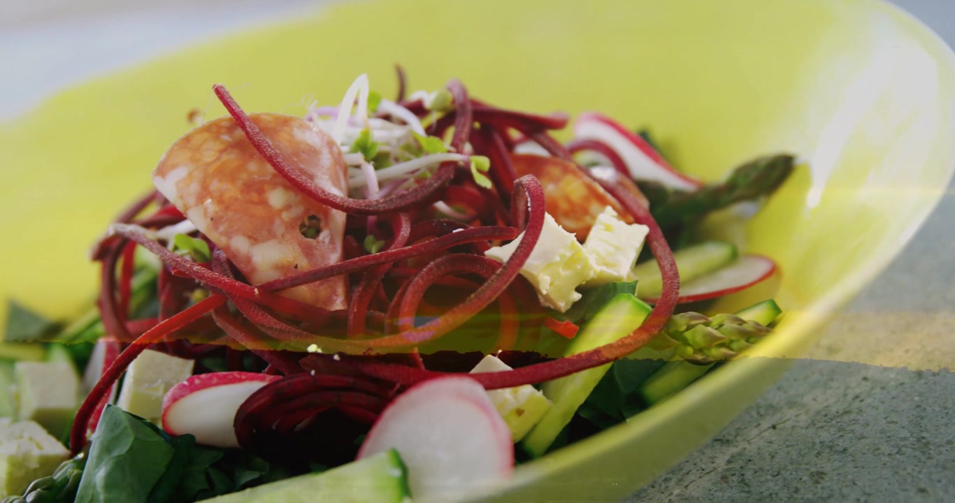 Vertical video: Camera moving closer, revealing lime-green bowl salad textures for food photography