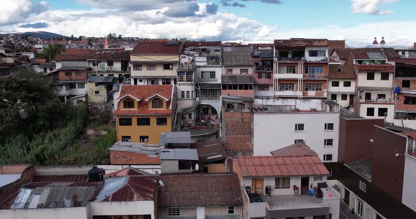 Filmagem aérea cinematográfica de drone capturando o centro histórico de Cuenca, Equador, e as famosas casas coloniais do Barranco com vista para o rio Tomebamba em um lindo dia claro e ensolarado na cidade
