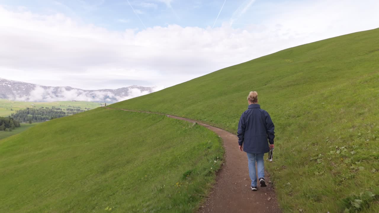 Woman walking along scenic Alpine hike trail. Dolomites POV follow shot