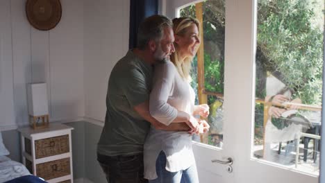 Happy-caucasian-mature-couple-talking-and-looking-through-the-window