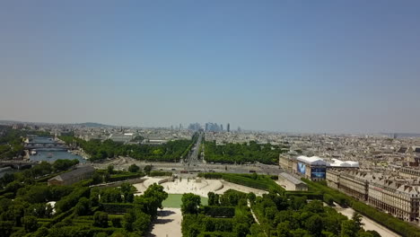 Aerial-ascending-footage-of-Tuileries-Garden-and-long-straight-and-wide-Champs-Elysees-boulevard.-High-rise-modern-business-buildings-in-La-Defense-borough-in-distance.-Paris,-France