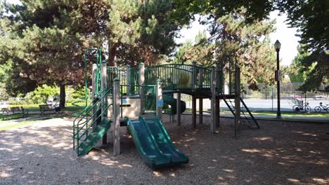 vista aérea lateral de un parque infantil desierto vacío y una cancha de tenis con avisos de restricción que respetan los estatutos de distanciamiento físico social del bloqueo de covid-19 junto a un poste de luz victoriano