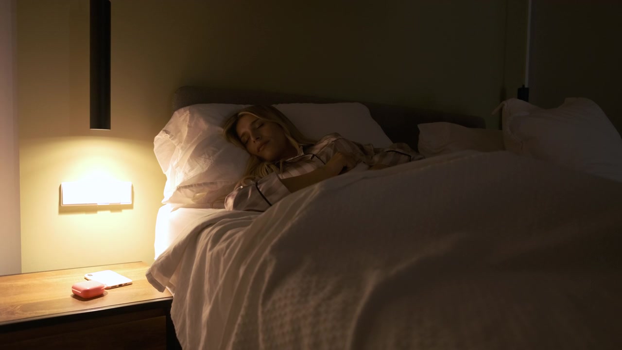 Ung kvinde sover fredeligt i sengen om natten
