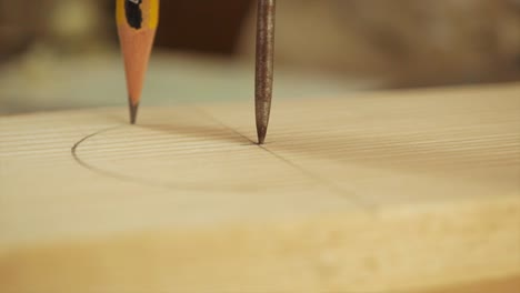 a macro shot of a carpenter using a compass on a piece of timber