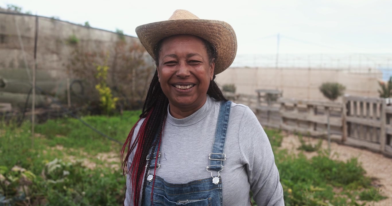 Happy African American Woman Farmer Smiling in a Garden