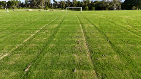 aerial view of a soccer field in gold coast, australia, showcasing lush green grass and goalposts under clear skies