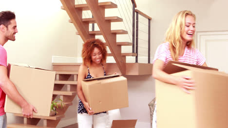 smiling friends moving boxes together