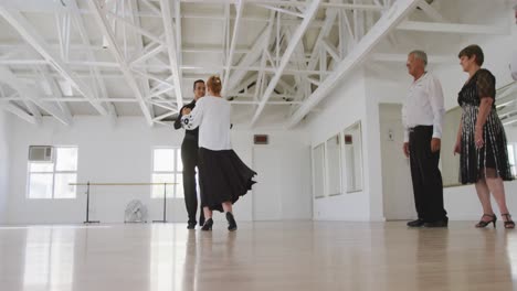 mixed-race-male-dance-teacher-taking-a-ballroom-dancing-class-at-a-dance-studio