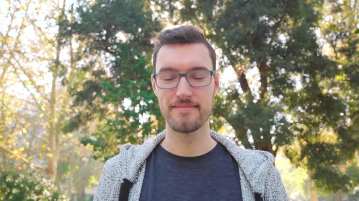 Giovane uomo con gli occhiali sorride con simpatia.